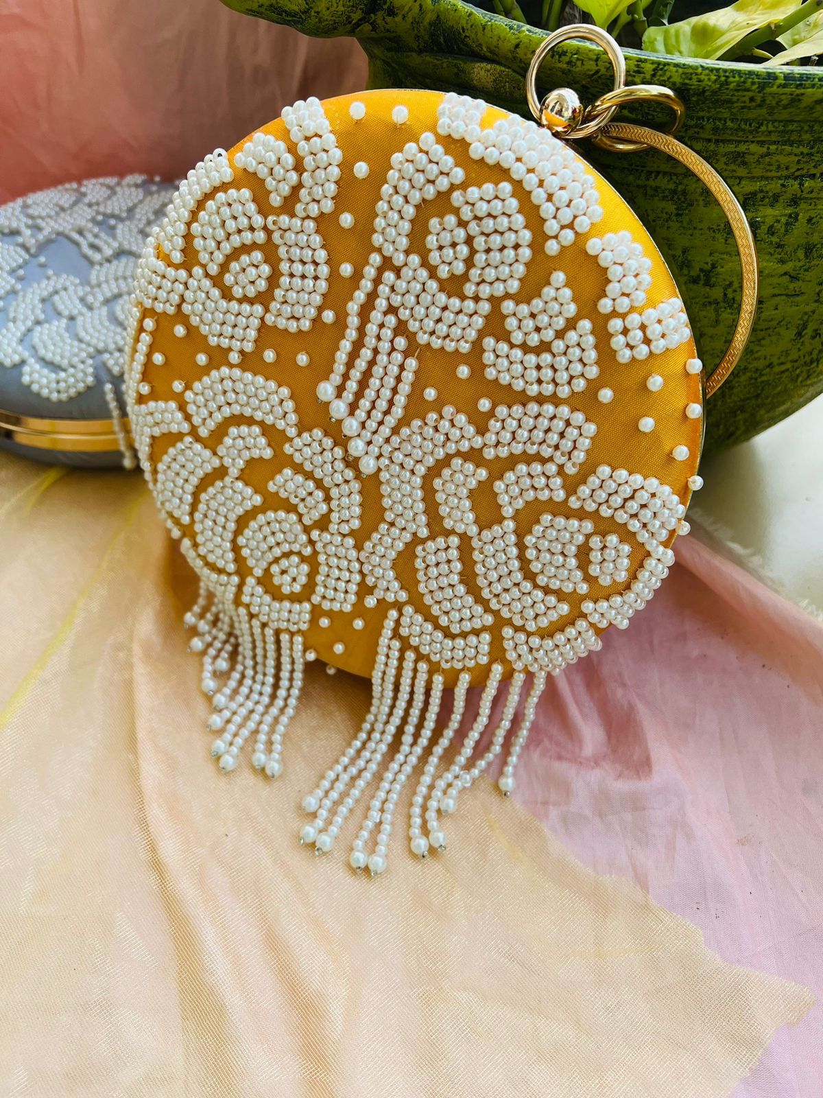 Round clutch with pearl work and latkans