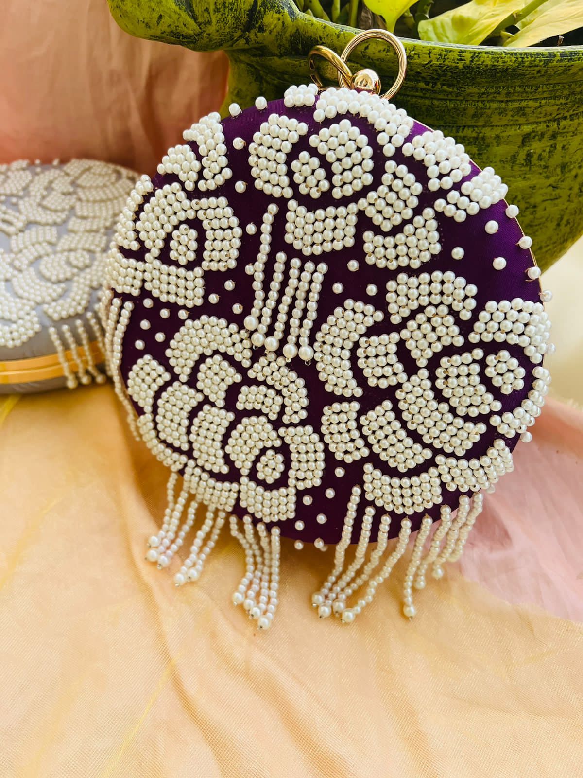 Round clutch with pearl work and latkans