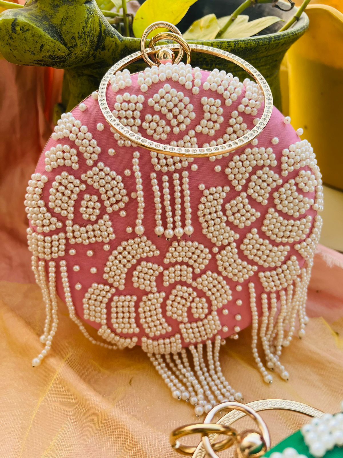 Round clutch with pearl work and latkans