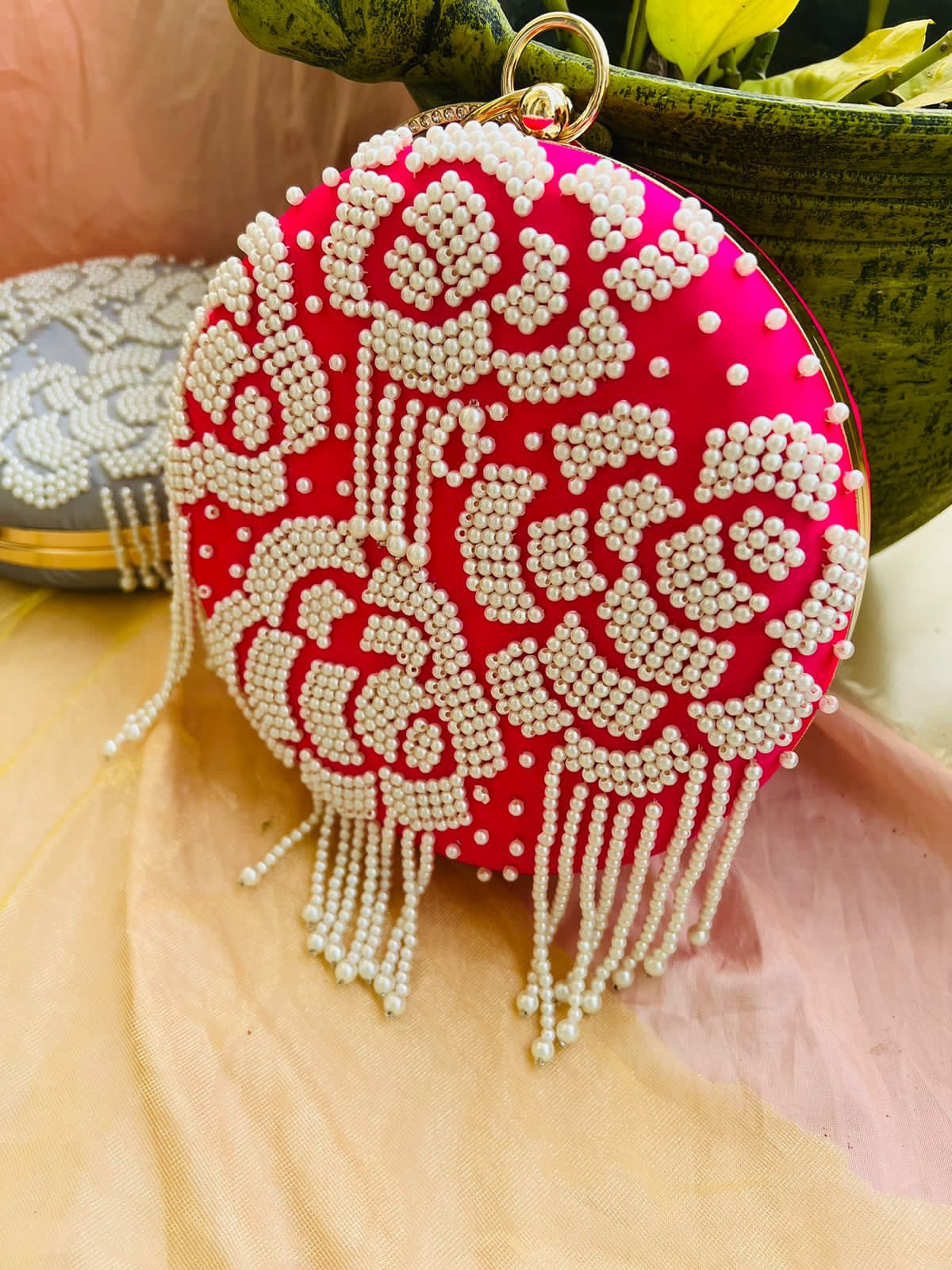 Round clutch with pearl work and latkans