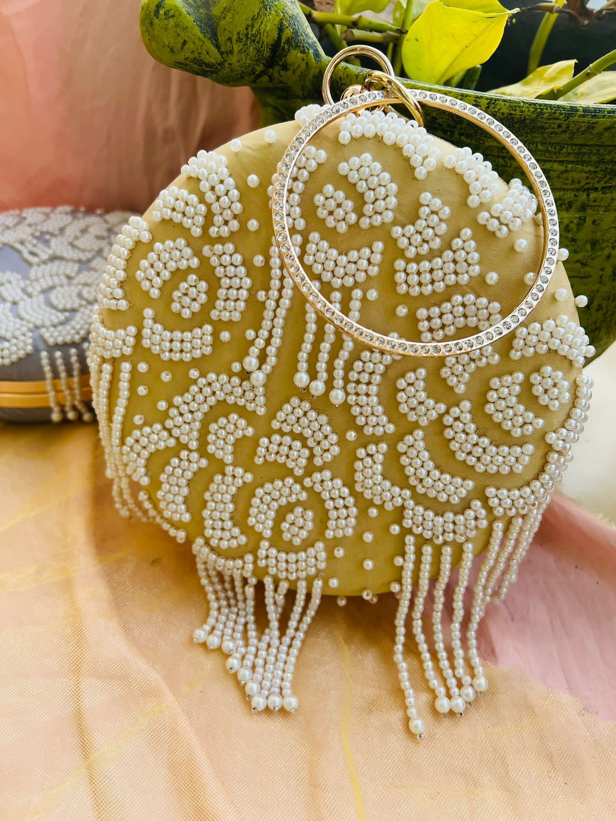 Round clutch with pearl work and latkans
