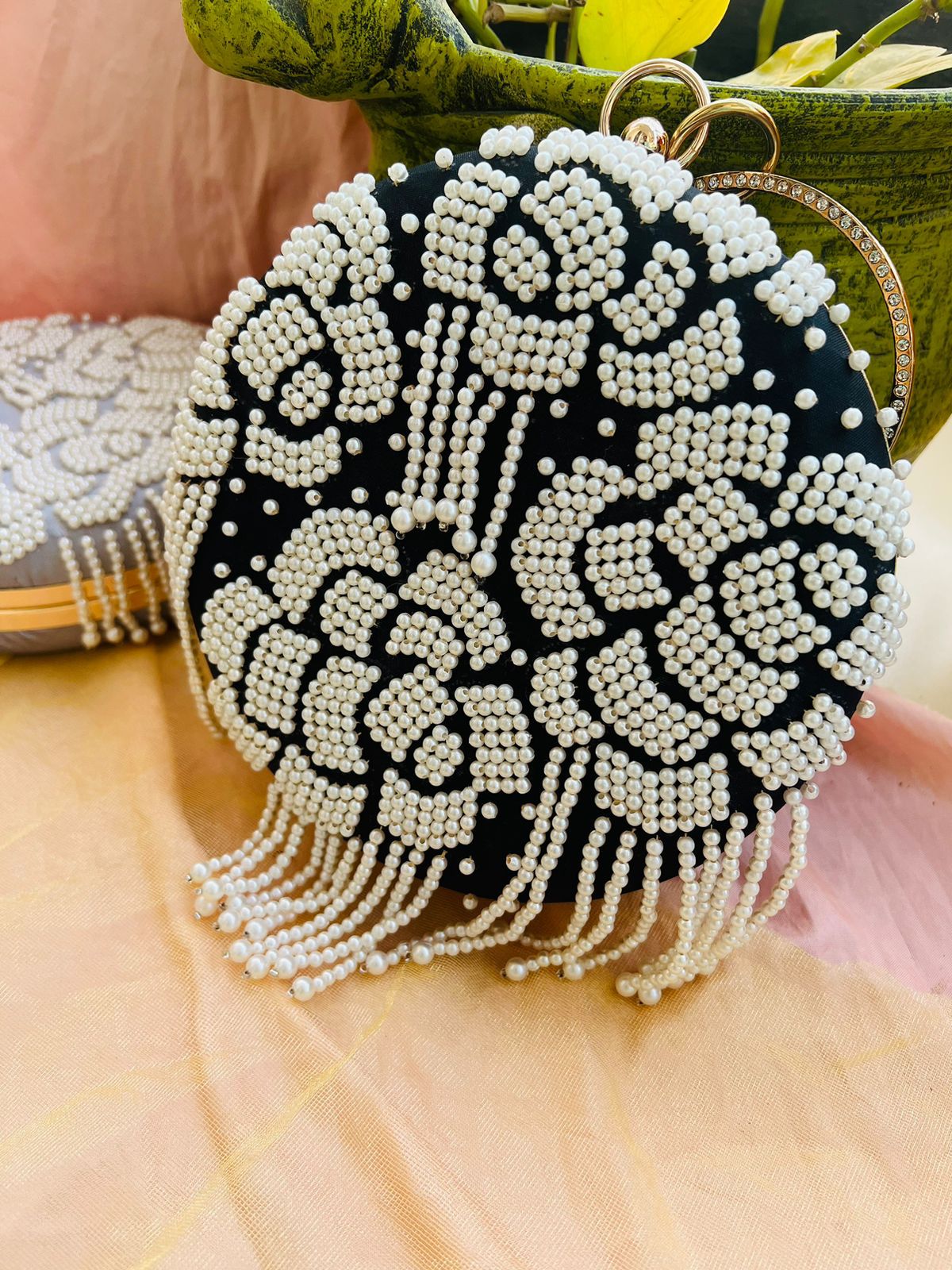 Round clutch with pearl work and latkans