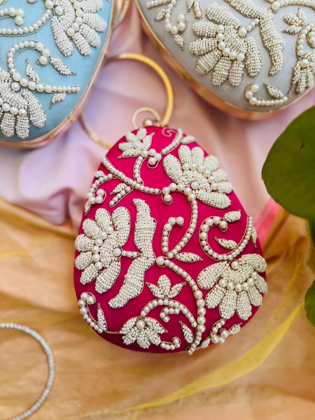 Oval clutch with pearl work and bangle