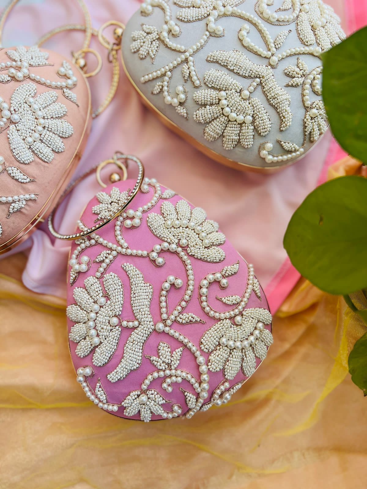 Oval clutch with pearl work and bangle