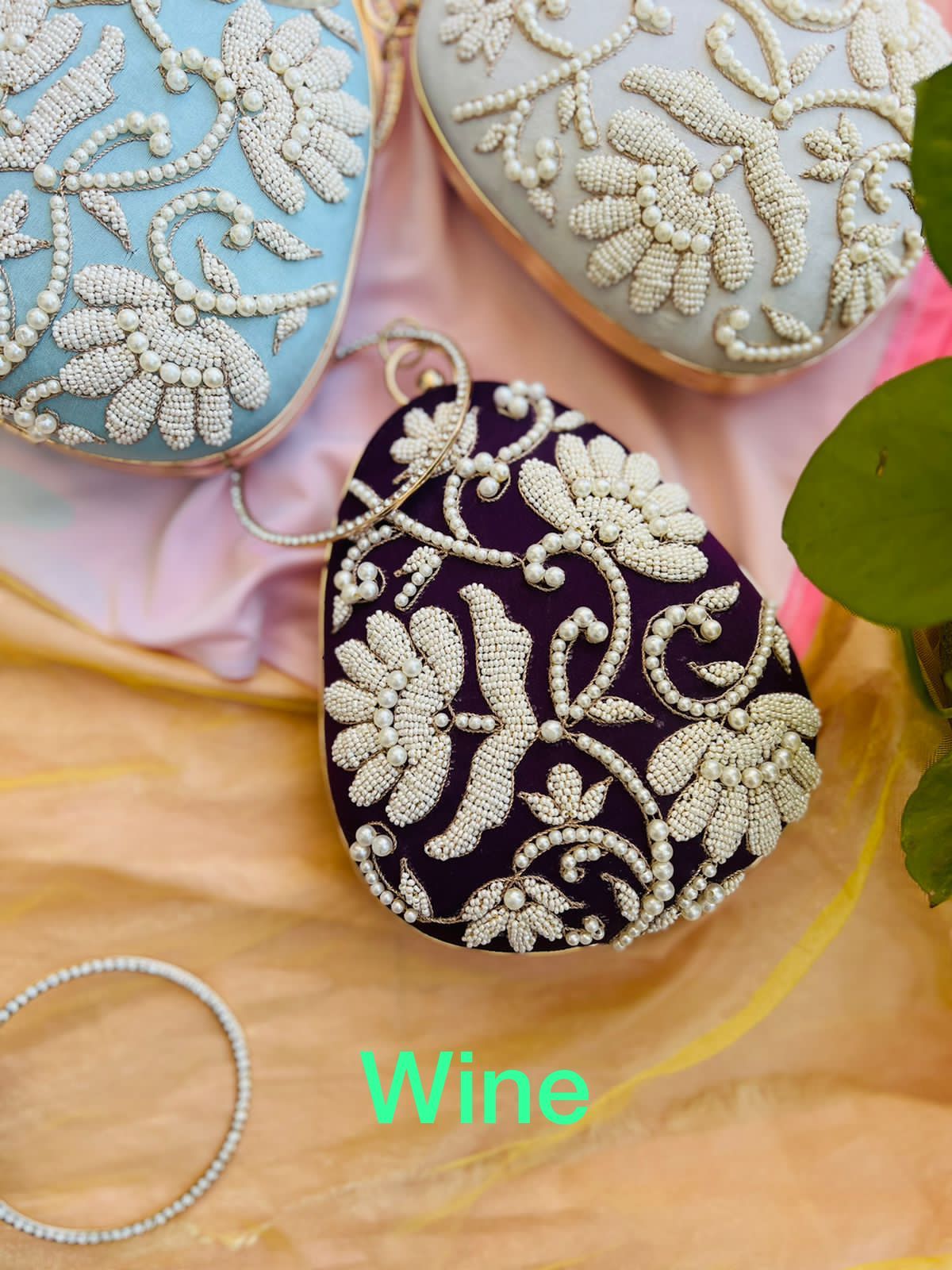 Oval clutch with pearl work and bangle