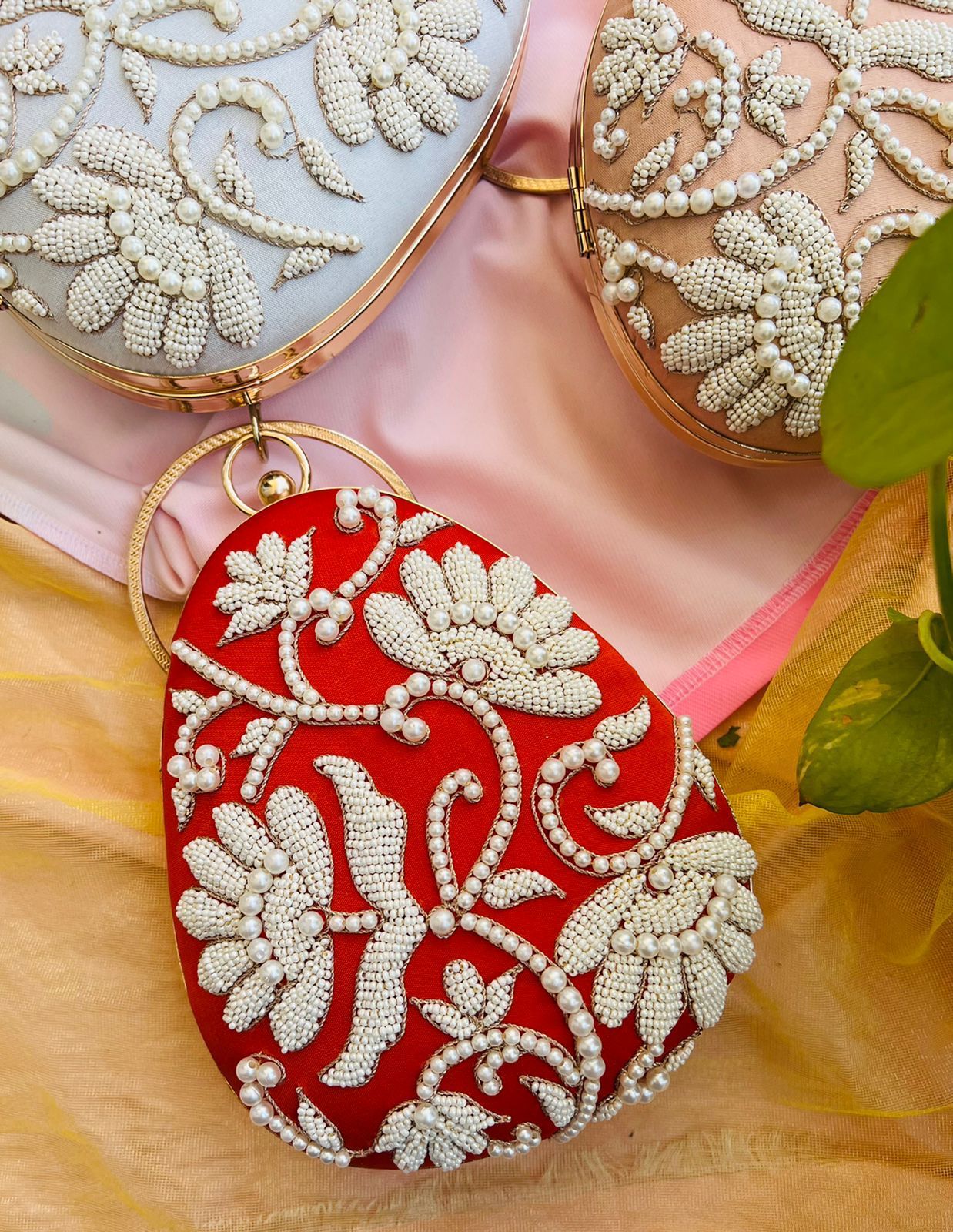 Oval clutch with pearl work and bangle
