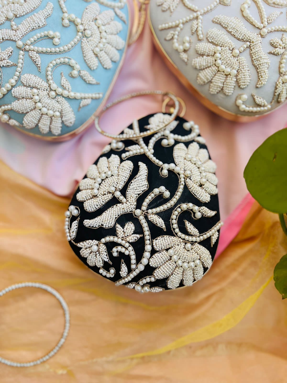 Oval clutch with pearl work and bangle