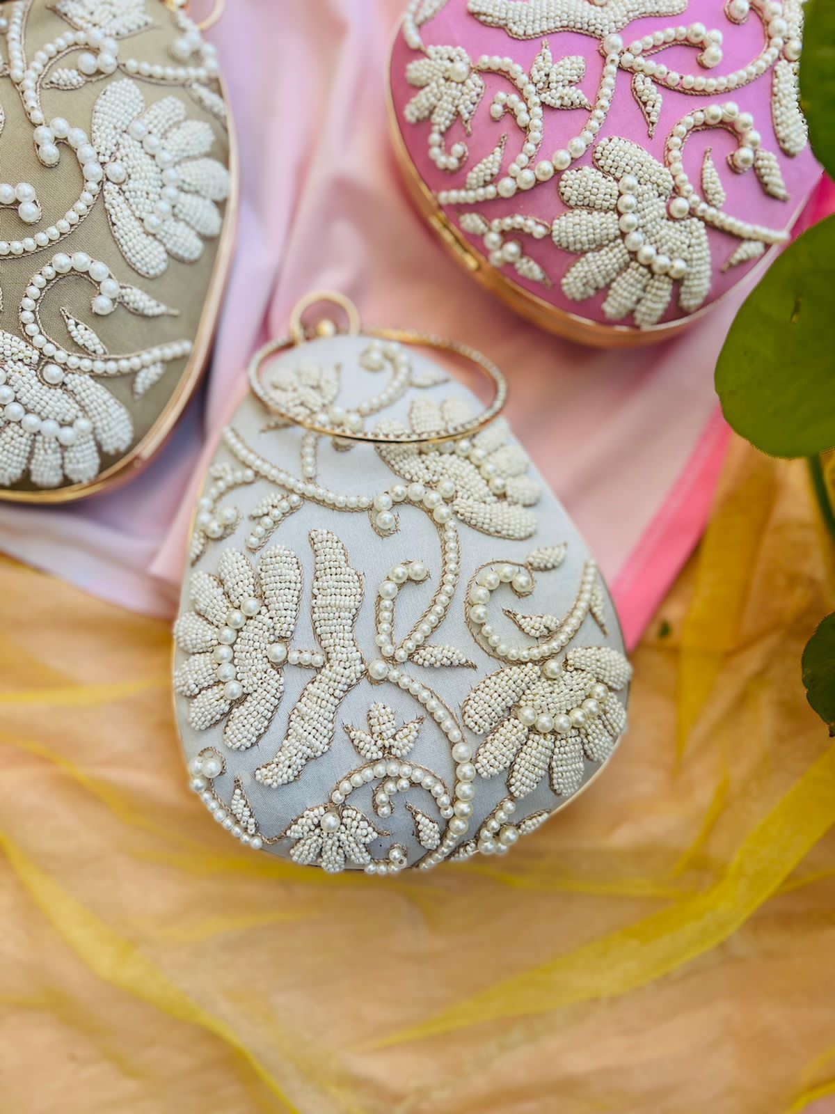 Oval clutch with pearl work and bangle