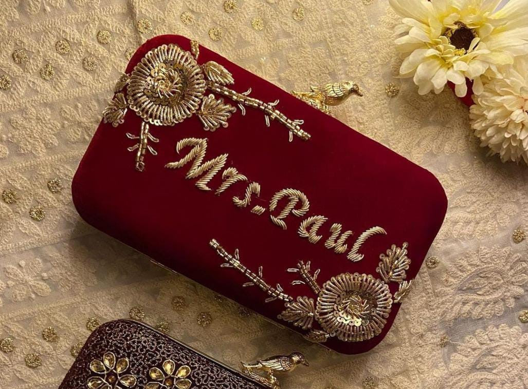 Golden embroidered velvet name clutch with bird knob