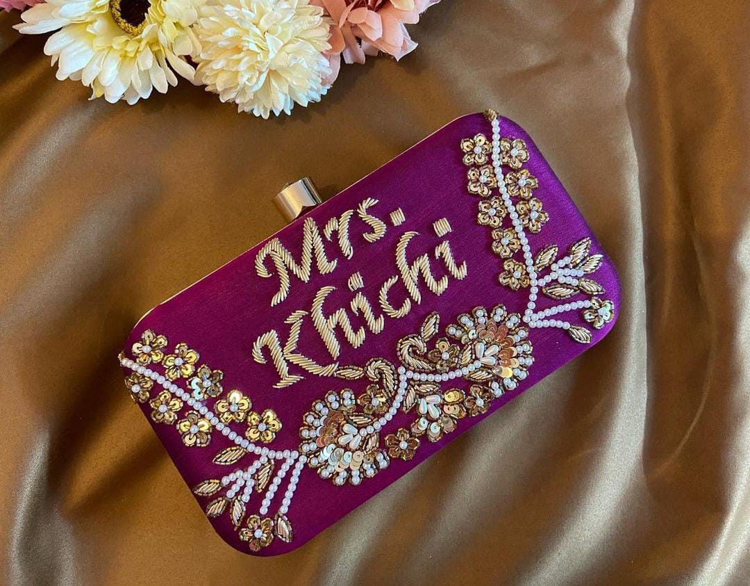 Purple clutch with golden piping work