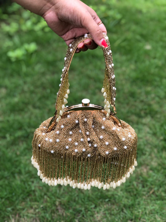 Golden half frame pearl potli bag with tassels