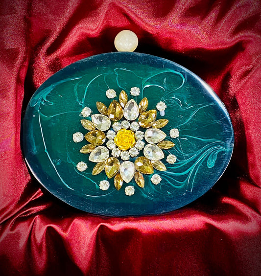 Oval emerald green resin clutch with round knob and glass stone work